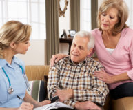 senior couple talking with caregiver