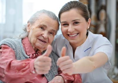 female nurse and senior woman doing a thumbs up